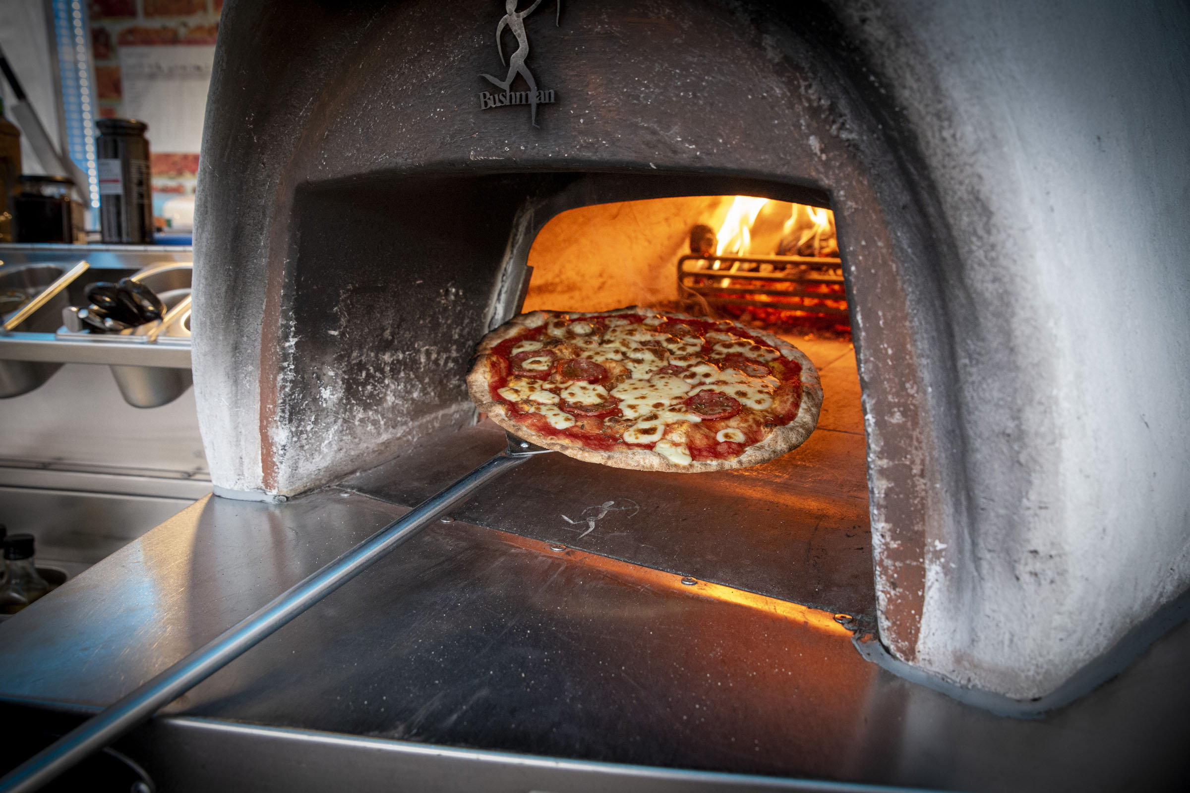 Wood-fired pizza being cooked in our traditional oven for wedding catering in Staffordshire