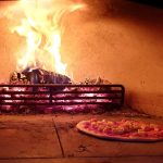 Neapolitan-style pizza cooking inside wood-fired oven at Staffordshire event