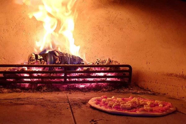 Neapolitan-style pizza cooking inside wood-fired oven at Staffordshire event