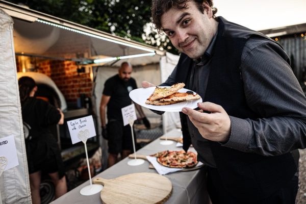 Wedding guest enjoying wood-fired pizza at Derbyshire reception
