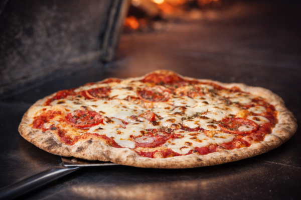 Freshly baked pepperoni pizza in wood-fired oven at a corporate catering event in Staffordshire